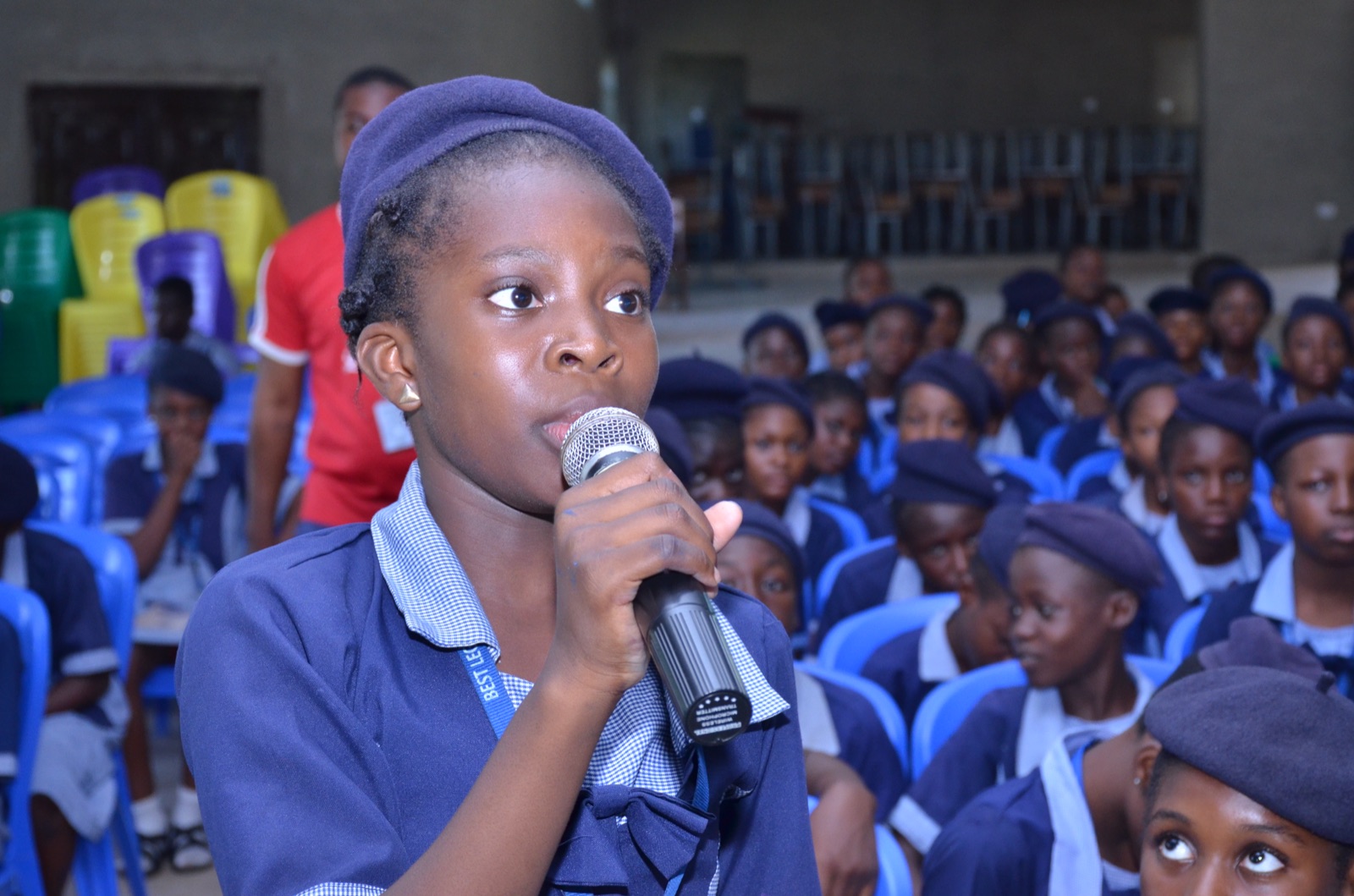 A student speaking into a microphone among classmates